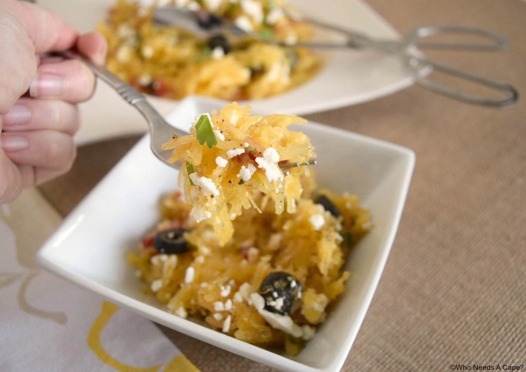 Mediterranean Spaghetti Squash Salad in a bowl and on a fork in someones hand.